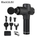 Black electric muscle massage gun with multiple attachment heads on a table.