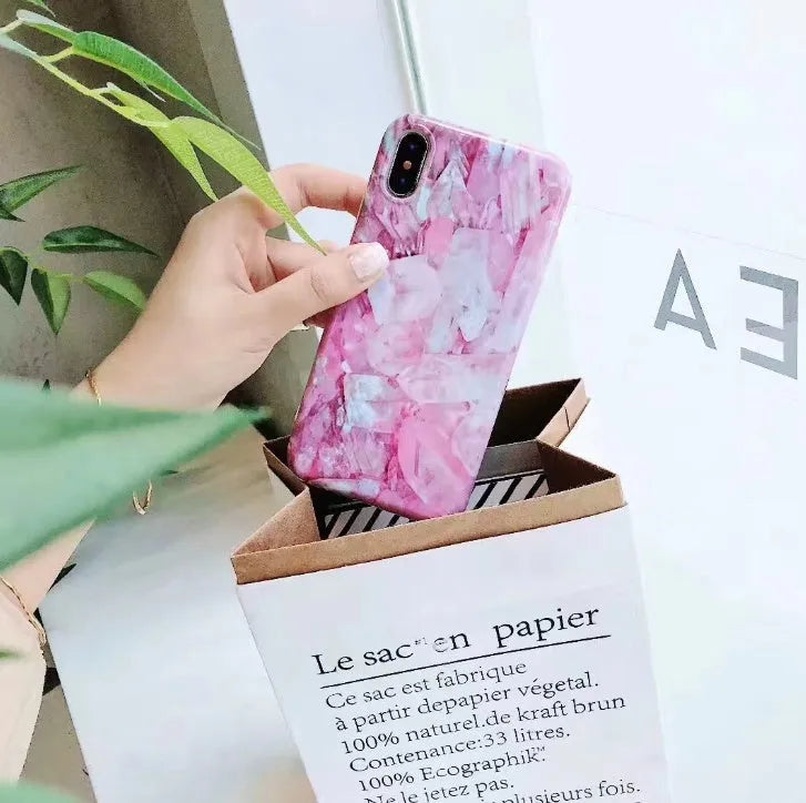 Colourful stone pattern soft protective case for iPhone X, 8, 7, 6, and 6s Plus models on a table.