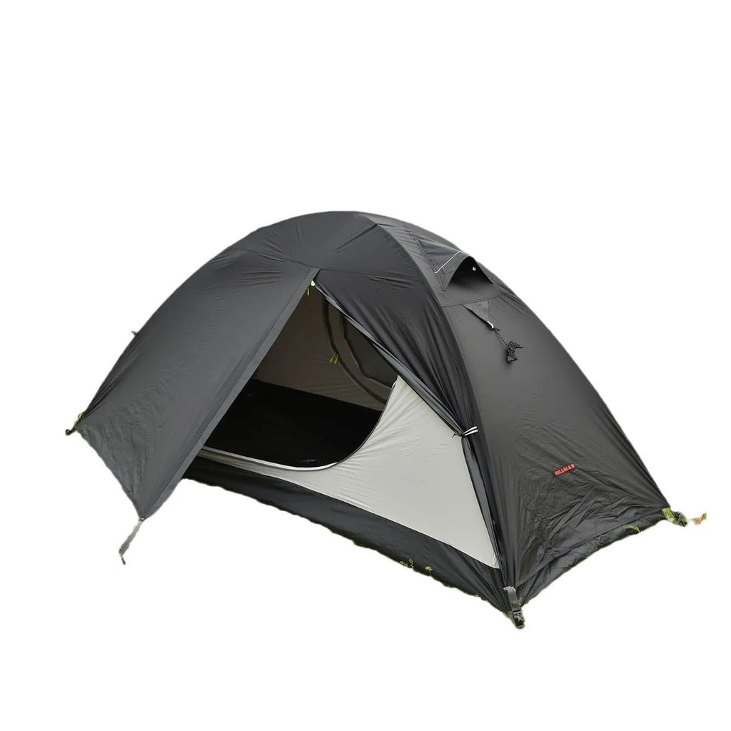 Red single-person double-layer backpacking tent with aluminium poles pitched in a grassy field