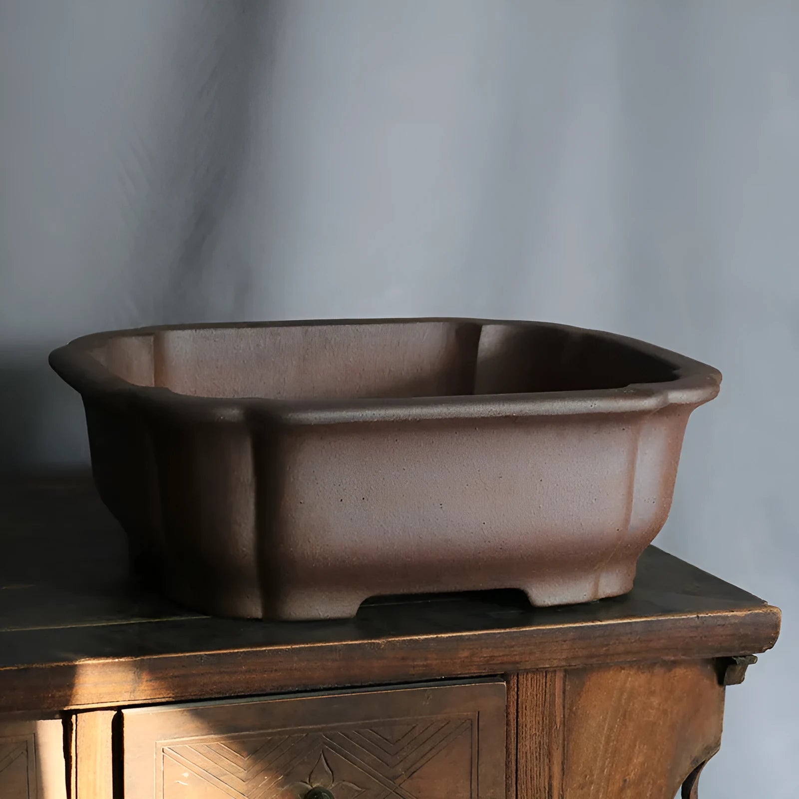 A rectangular purple sand clay bonsai pot on a floor, showing its modern simple design.