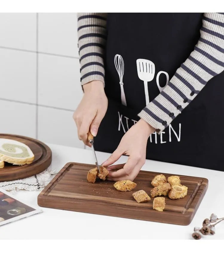 Black walnut wood cutting board set showing rectangular and round boards with juice grooves and side handles