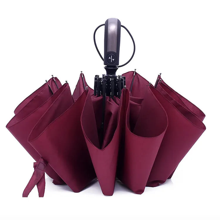 Open black automatic triple-folding business umbrella with a large canopy and rubber handle.