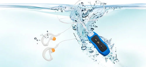Compact black waterproof MP3 player earphone with USB cable, shown next to a ruler for scale.