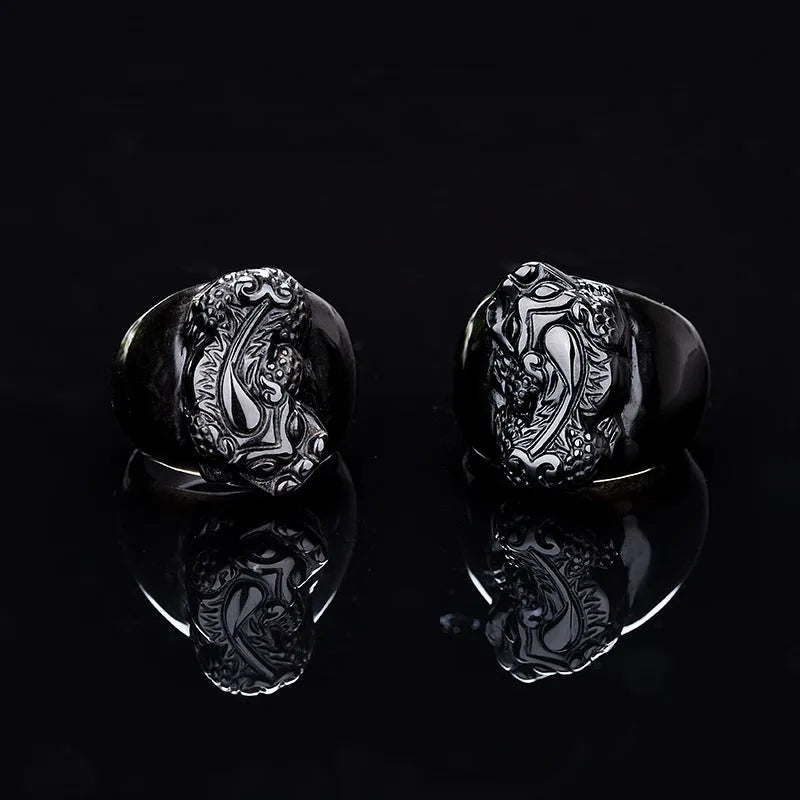 Men's black obsidian Pixiu thumb ring with gold sheen on an alloy band, showing side profile.