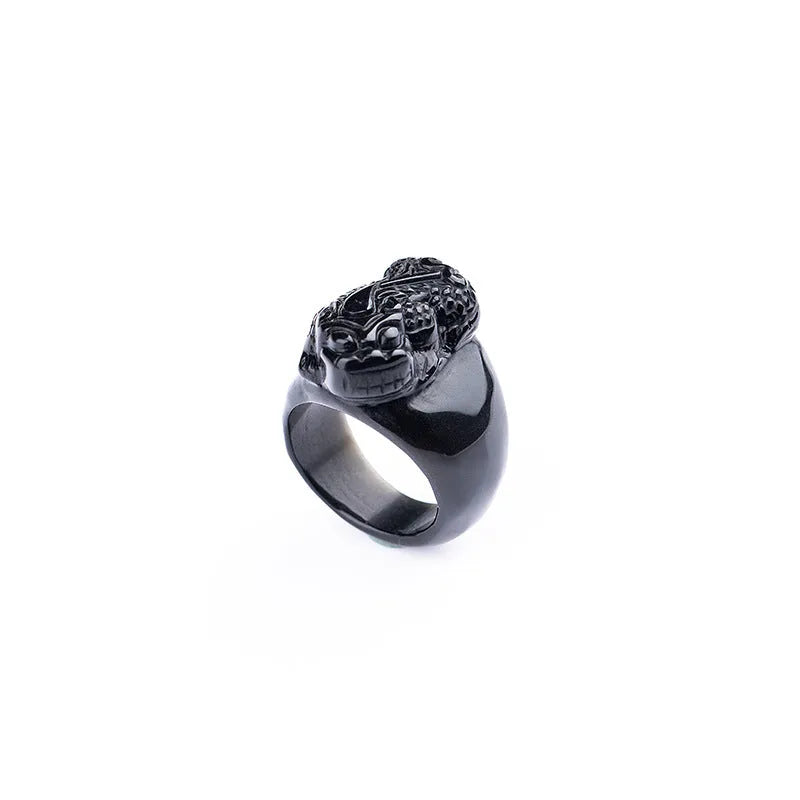 Men's black obsidian Pixiu thumb ring with gold sheen on an alloy band, showing side profile.