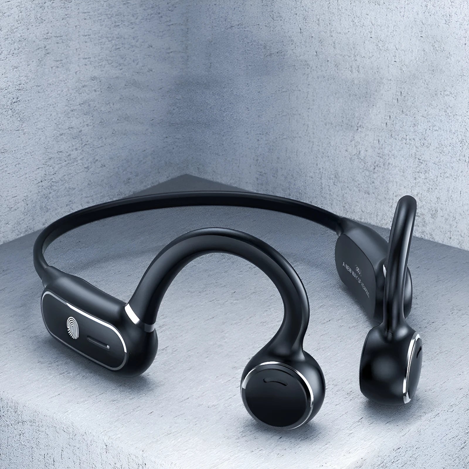 Black air conduction Bluetooth wireless earphone with titanium wire frame shown hanging over a pair of glasses.