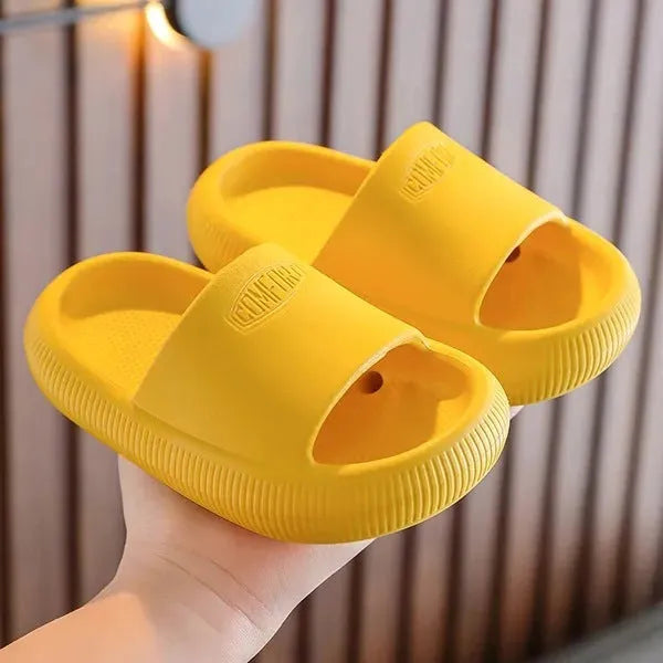 Colourful children's EVA slippers with textured sole, shown in blue, green, orange, pink, and yellow.