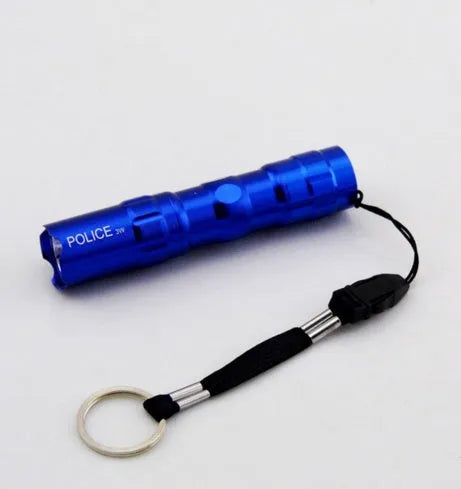 Black aluminium mini LED flashlight showing scale next to a AA battery.