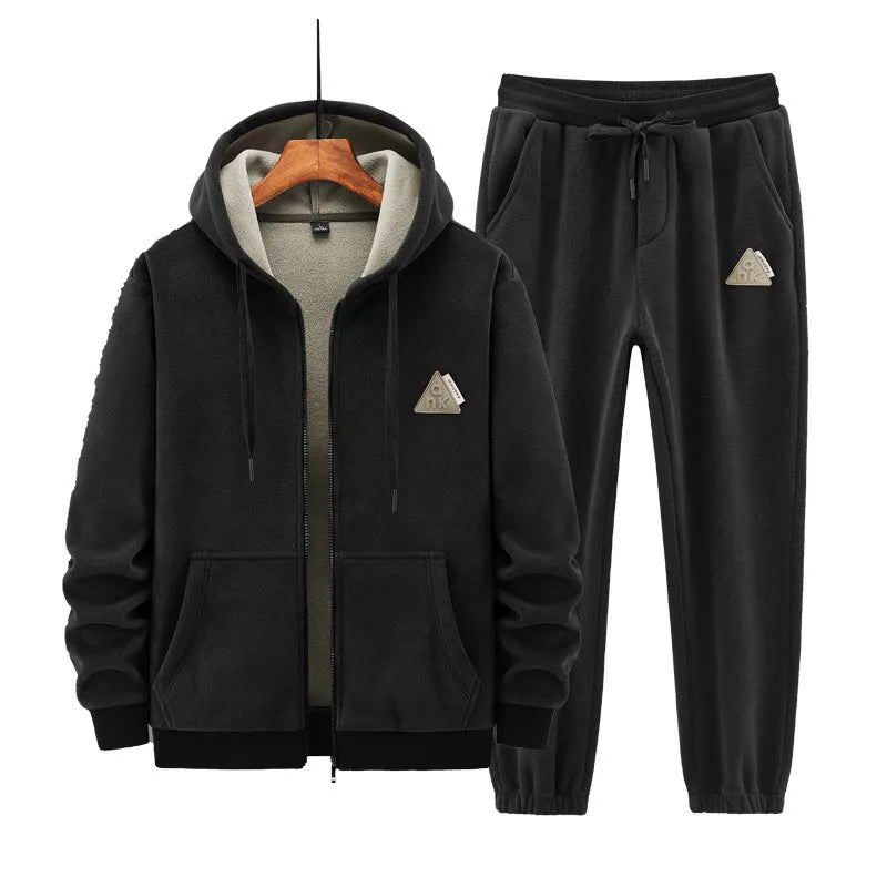 Man wearing a grey hooded sweatshirt and matching tracksuit pants from a casual two-piece set.
