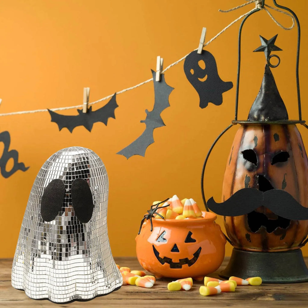 Silver glass Halloween ghost decoration with mosaic mirror patch design on a desktop.