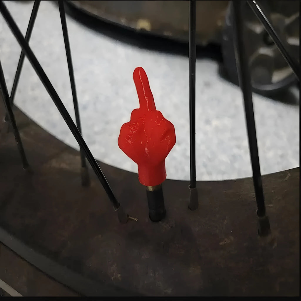 Four latex tyre valve caps showing two skin colour and two black pieces for car tyre protection