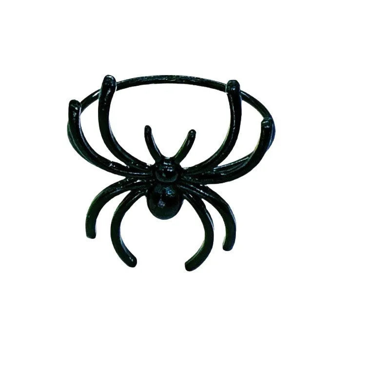 Set of six black alloy napkin rings with detailed spider sculpture for Halloween table decor.