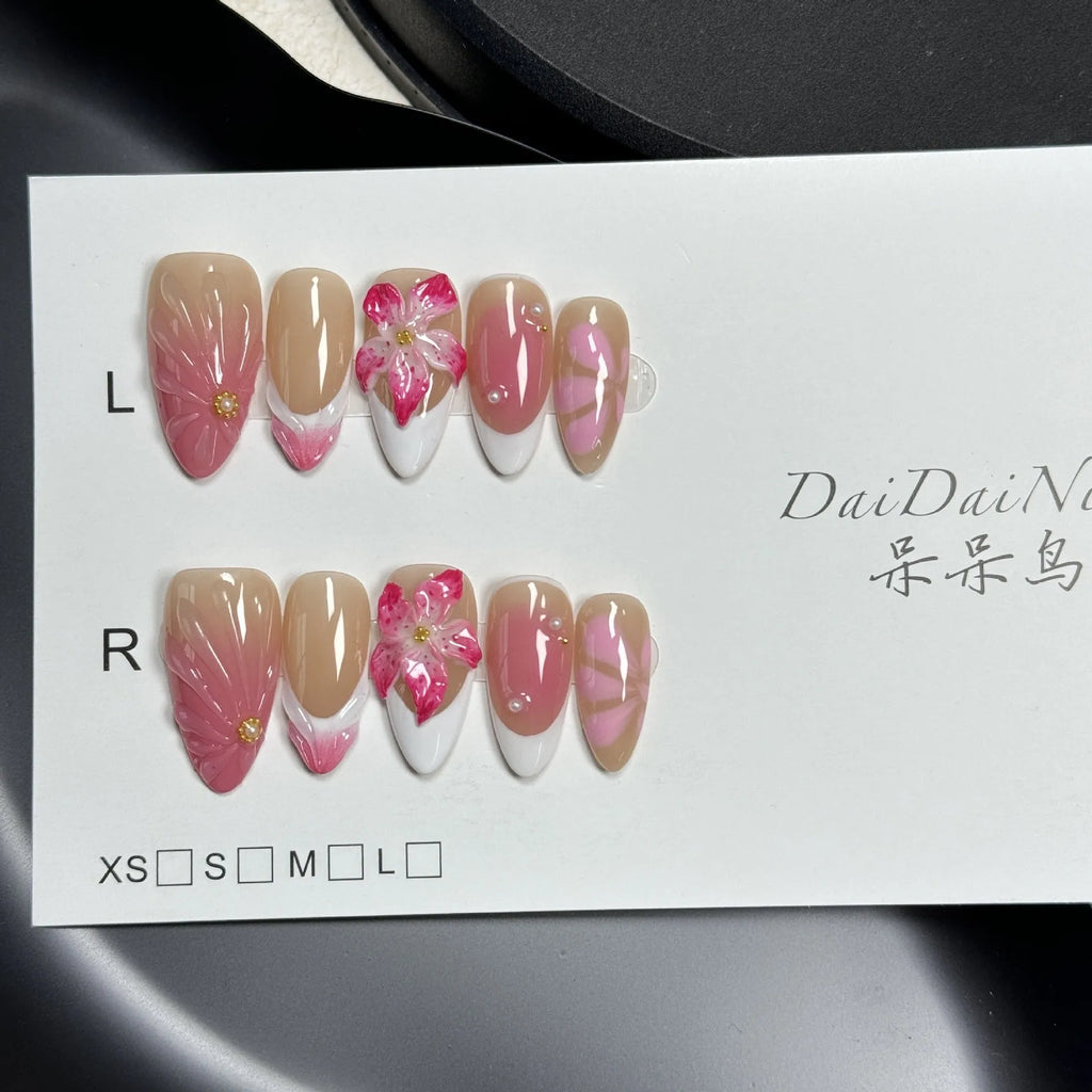 Set of white plastic almond-shaped nail tips with 3D raised lily and ice flower French manicure design.