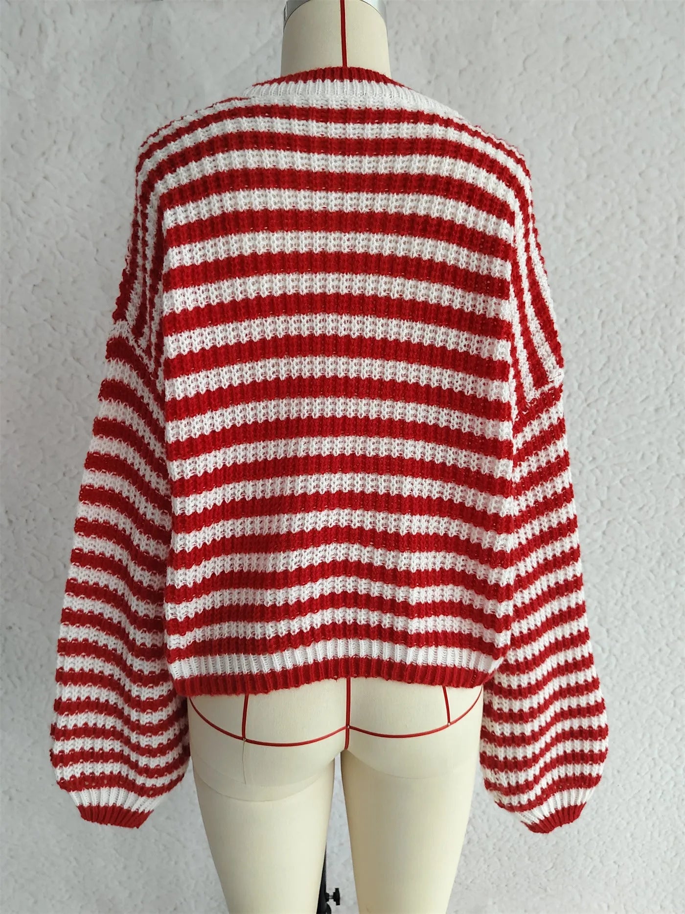 Women's loose vintage stripe knit pullover sweater in black on a hanger.