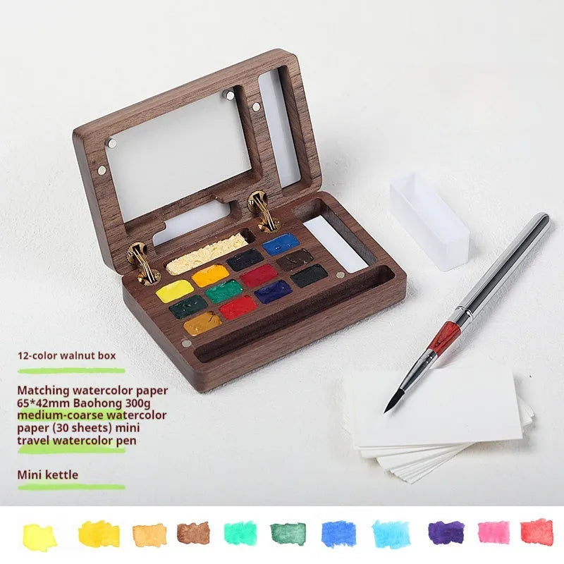 Mini wooden watercolour paint box with walnut finish, open to show pigment suit selection.