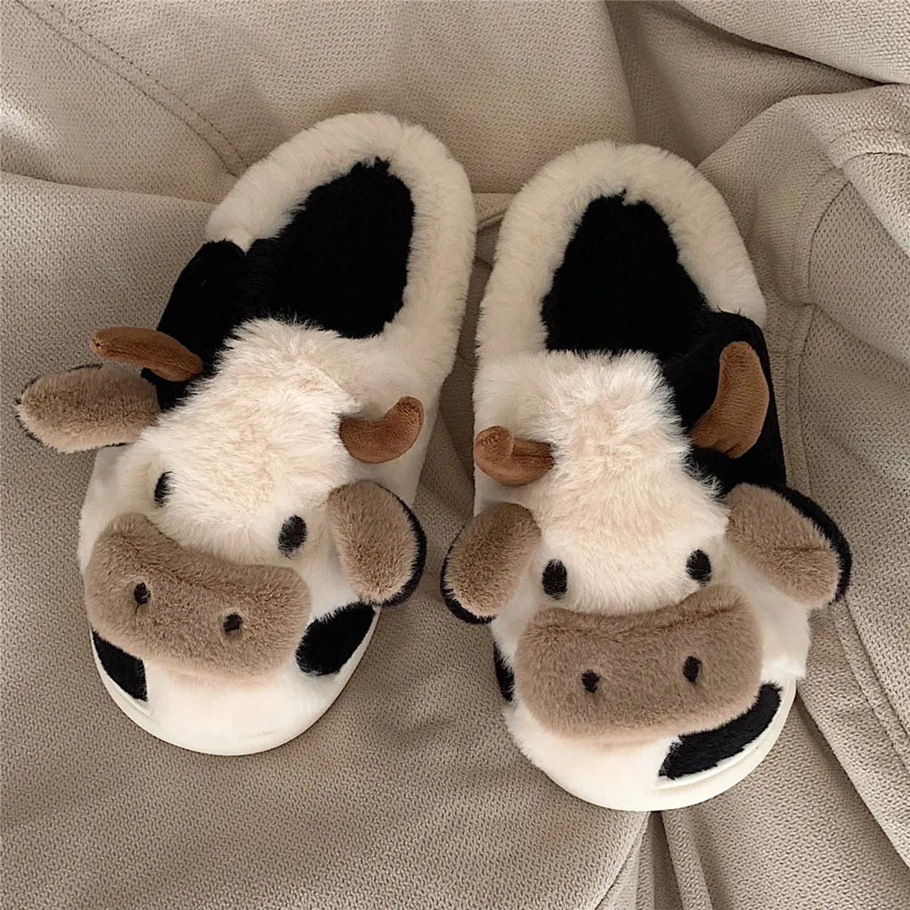 White women's cow slippers with fluffy faux fur, cartoon face, and textured non-slip sole.