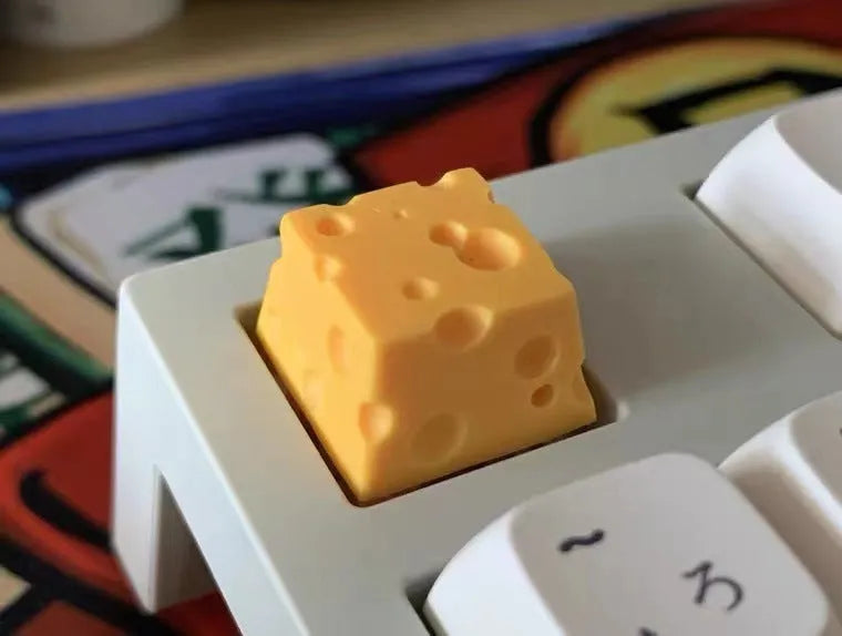 Yellow resin cheese character key cap for mechanical keyboards on a white background.