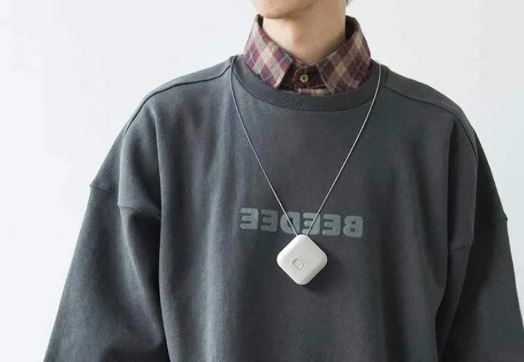 Pink portable USB air purifier necklace with charging cable showing compact wearable design