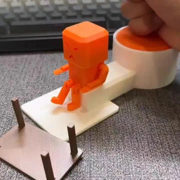 Orange plastic decompression toy with table-turning mechanism on flat surface