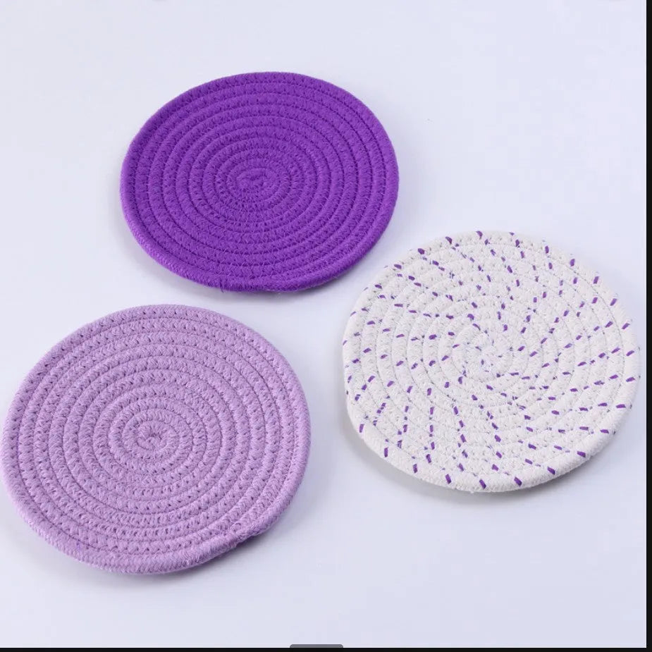 Three round cotton cord coasters in blue, measuring 18cm diameter, on wooden table