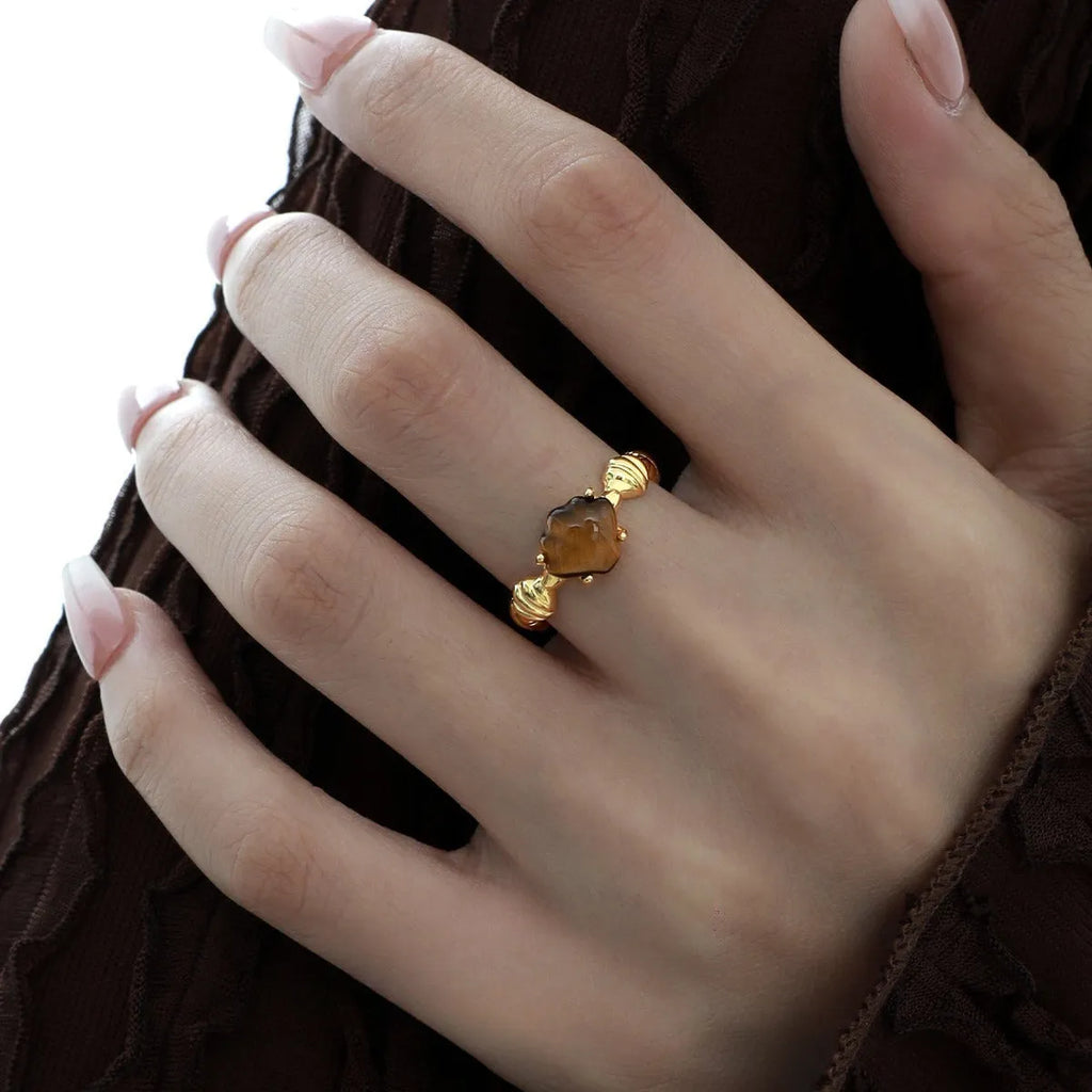 Adjustable silver ring with natural white shell and tiger eye detail, shown in white gold and 18K gold electroplated finishes.