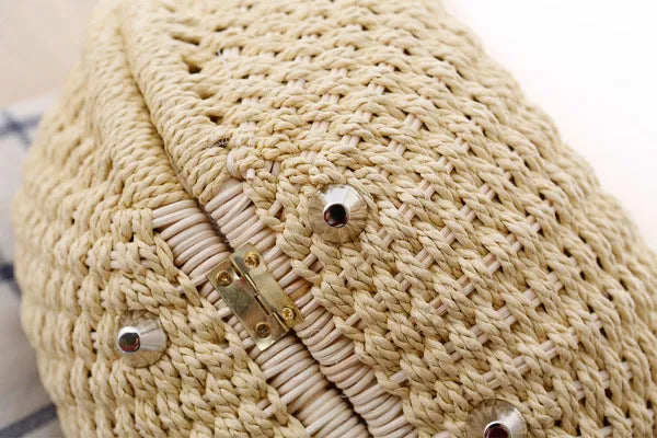 Women's round woven paper rope handbag in beige with hard shell, cover closure, and hard handle
