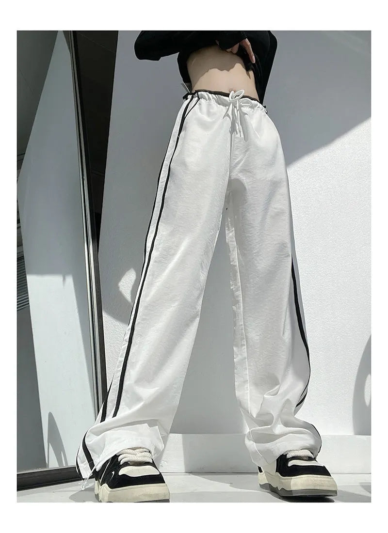 Women's navy blue straight-leg trousers with a white contrast ribbon detail sewn along the side seams.