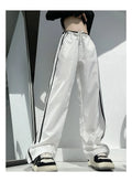 Women's navy blue straight-leg trousers with a white contrast ribbon detail sewn along the side seams.