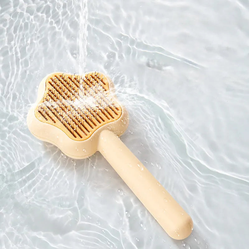 Green self-cleaning pet comb with stainless steel needles on a white background.