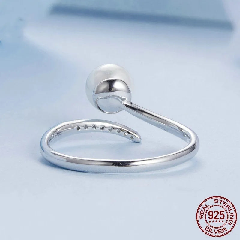 Silver-coloured adjustable open loop ring with a natural white shell pearl setting.