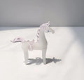 A smooth glazed horse figurine ornament in a modern minimalist style on a table.