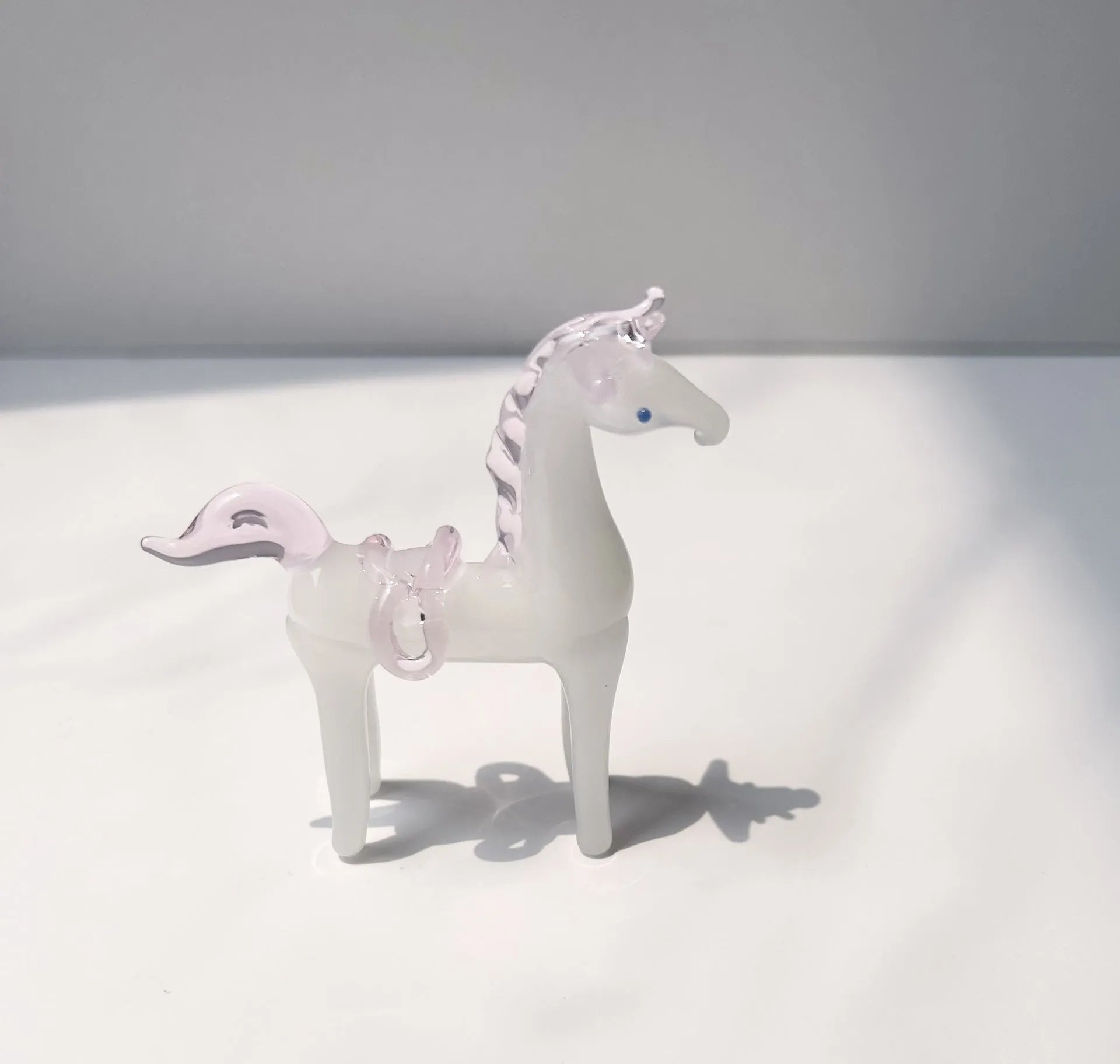A smooth glazed horse figurine ornament in a modern minimalist style on a table.