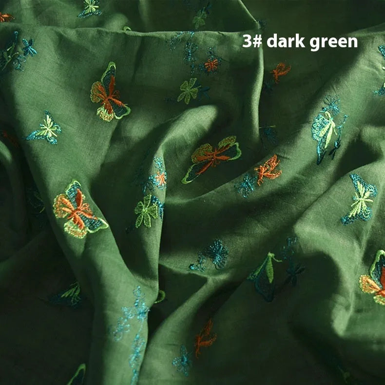 Roll of beige, grass green, and dark green 100% ramie fabric showing its texture and 140cm width.