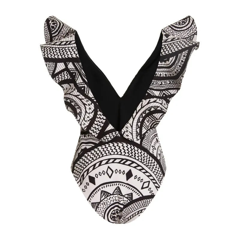 Women's vintage printed deep V-neck one-piece swimsuit with a matching wrap skirt laid flat.