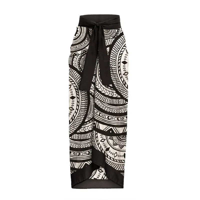 Women's vintage printed deep V-neck one-piece swimsuit with a matching wrap skirt laid flat.