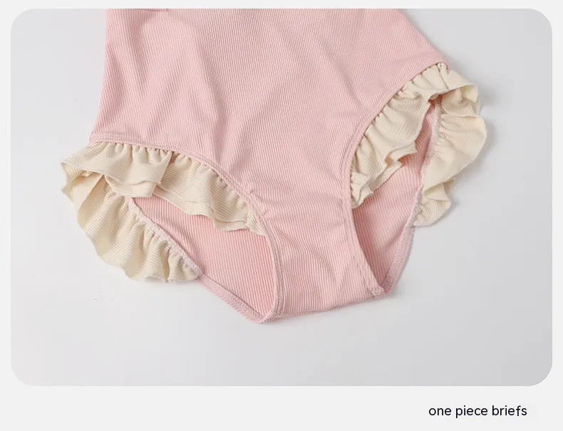 Pink women's conservative one-piece swimsuit with a Siamese design detail on a mannequin.