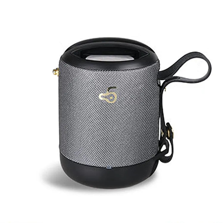 Compact black waterproof bluetooth speaker with portable belt on a table