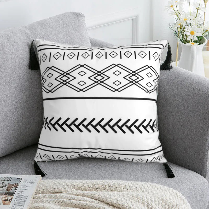 Bohemian style decorative throw pillow with polyester cover in light grey on a sofa.