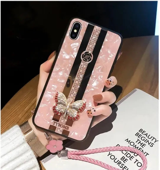 Luxury acrylic iPhone case with crystal butterfly design and mirror back, shown in purple.