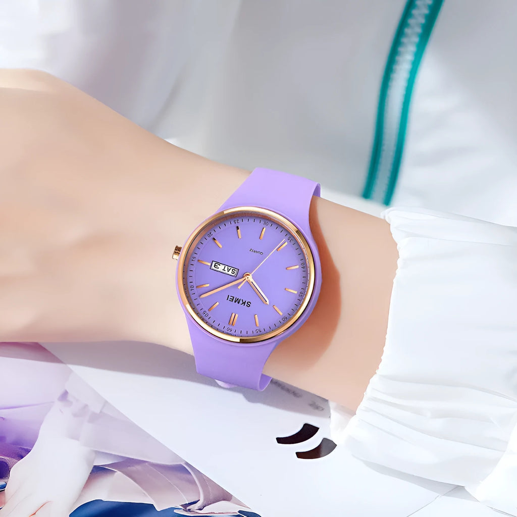 A women's silicone strap quartz watch with calendar on a white dial, showing a stainless steel pin buckle.