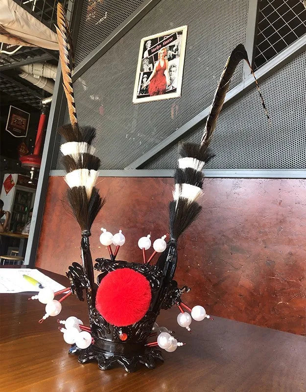 Zijin Crown gold motorcycle helmet feather ornament with long black plume attached to a black helmet.