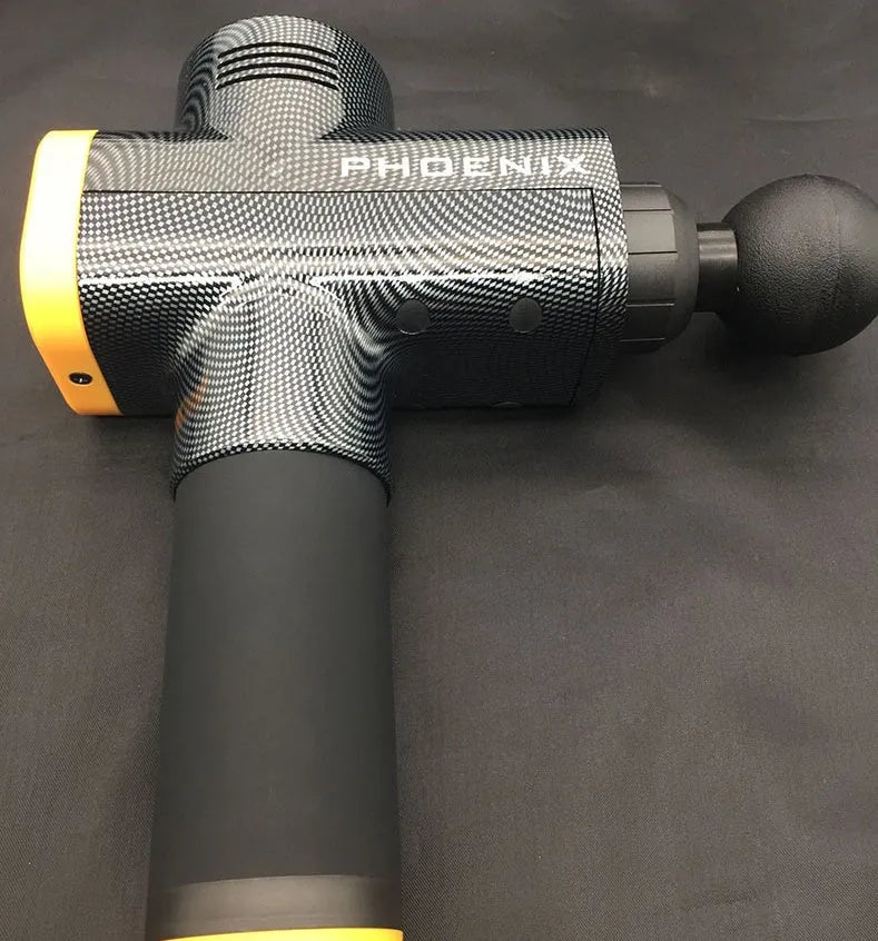 A black or silver ABS plastic percussion massage gun with four different removable massage heads on a table.