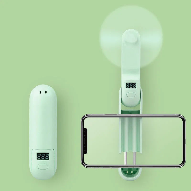 A green folding mini USB fan with plastic blades, shown in open and closed positions.