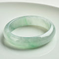 Light green jade bracelet on wrist showing natural stone texture and colour