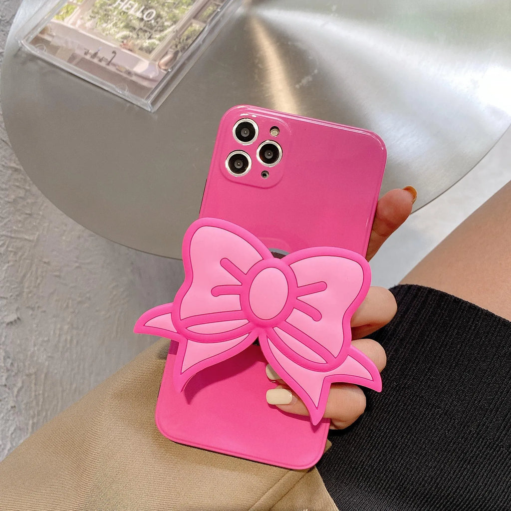 Rose red iPhone case with a large pink bow and a folded-out kickstand on the back.