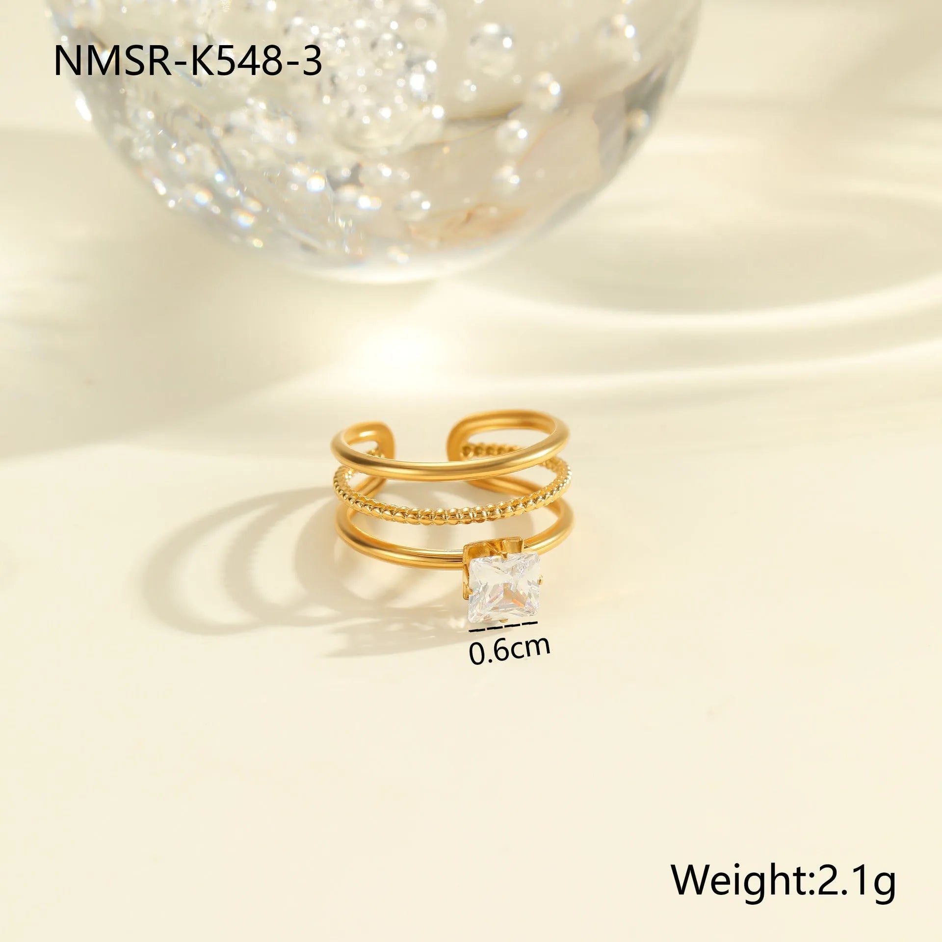 Gold electroplated adjustable ring with geometric zircon design on a stainless steel band.