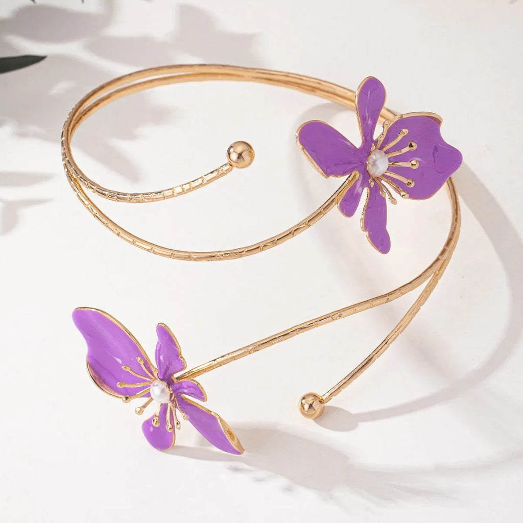 Pink hollow metal bangle with engraved pattern on a wrist, showing its open design and lightweight profile.