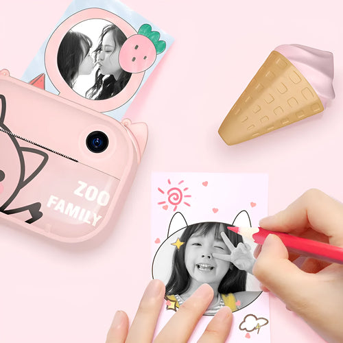 Pink C3 instant print digital camera with 2.4-inch screen, placed alongside included printing paper, stickers, and accessory pack
