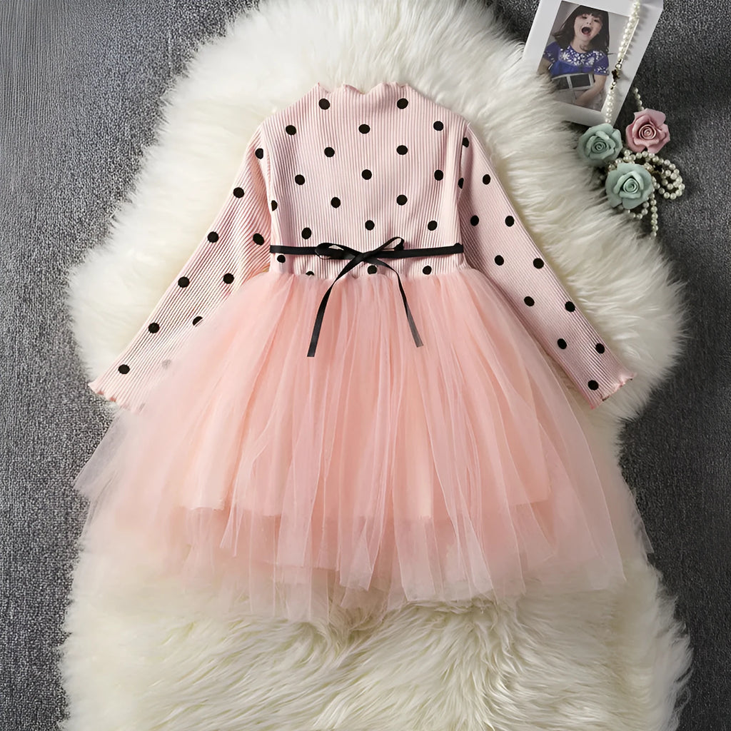 Baby girl wearing a long sleeve black tutu lace dress for a first birthday party.