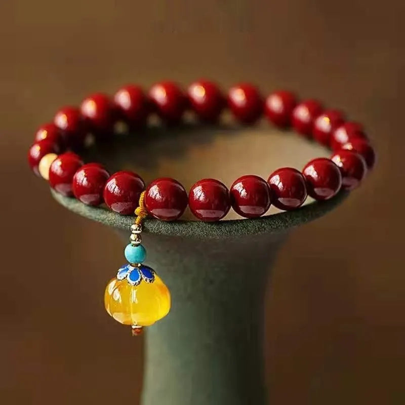 Handmade gold cinnabar wave bracelet showing genuine stone and copper bead construction in national style design